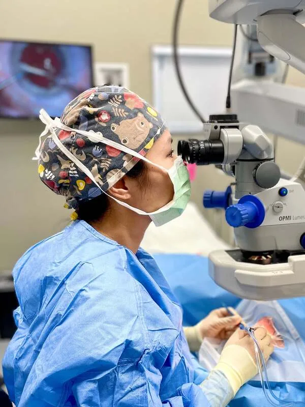 Dr. Audrey Tai performing surgery through an operating microscope